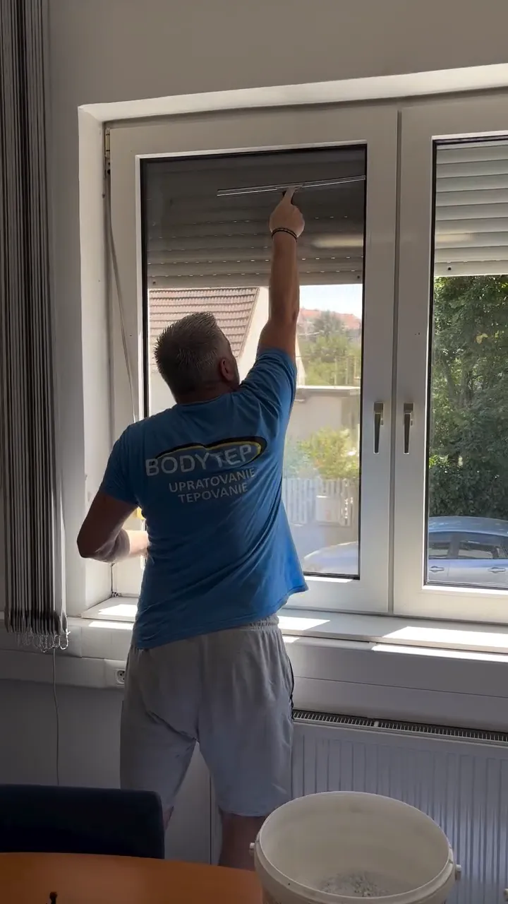 Video: pracovník umýva plastové okno zvnútra stierkou