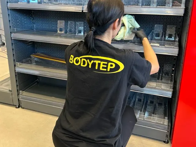 Pracovníčka BODYTEP utiera police kovového regálu vo firemnom priestore